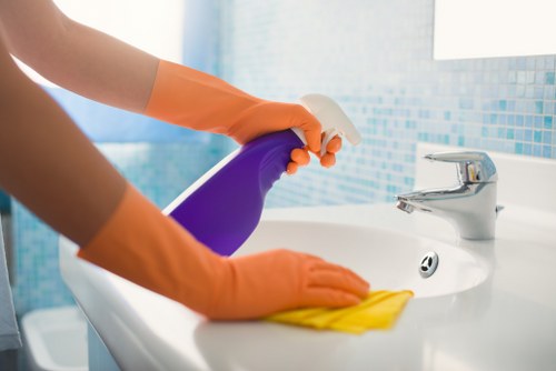 Cleaner preparing a living area in a central London flat